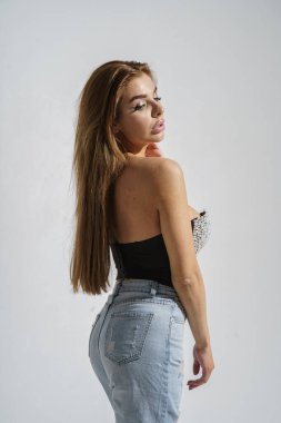 Stüdyoda gri arka planda poz veren şık esmer.  
