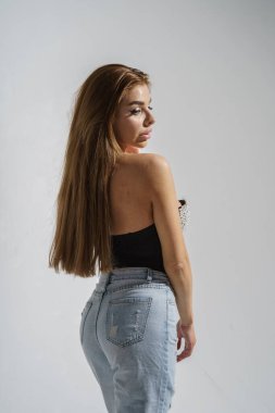 Stüdyoda gri arka planda poz veren şık esmer.  