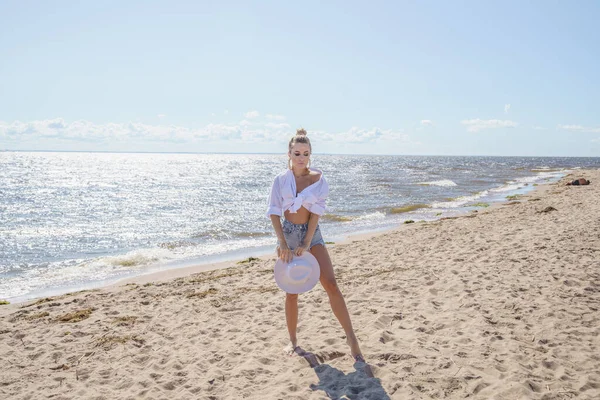 셔츠와 청바지 바지를 아름다운 여인의 초상화 해변에서의 — 스톡 사진