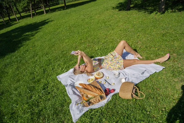 夏服の美しさブロンドの女性の屋外肖像画 緑の公園でピクニックに休んでモデル — ストック写真