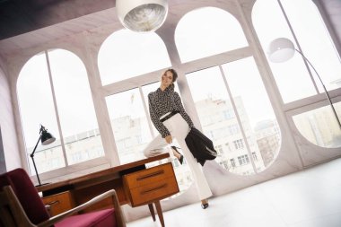 Lüks dairelerde poz veren güzel genç bir kadın. Gayri resmi giyinmiş esmer bir kadın portresi. 