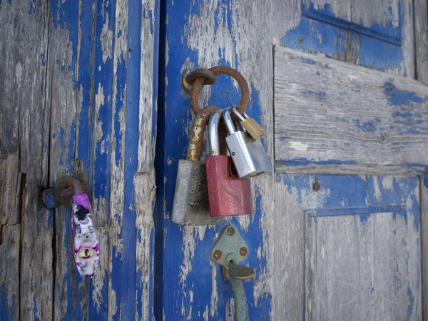 A family of door locks on a rustic blue door