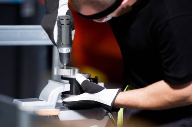 bir tornavida ile çalışan bir çalışma tezgahında bir t-shirt çalışan adam