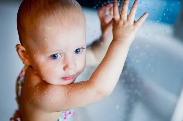 Baby Mädchen im Badeanzug genießt Wasser in der Dusche — Stockfoto