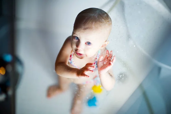 Baby Mädchen im Badeanzug genießt Wasser in der Dusche — Stockfoto