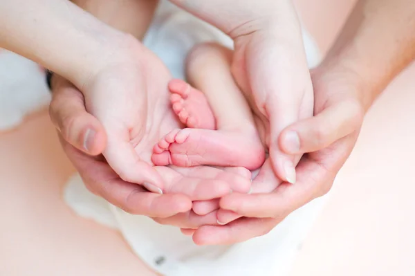 Hands of parents support the childs legs in the palms — Stock Photo, Image