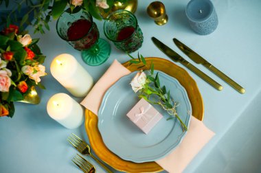 altın tabak ve çatal bıçak takımı ile turkuaz renkli masa