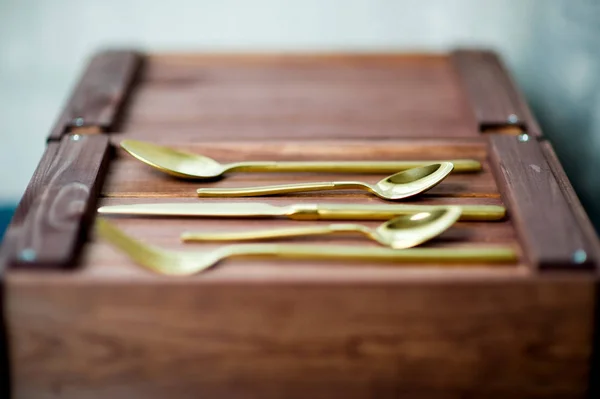 Cubiertos de oro en una tapa de cajón de madera — Foto de Stock