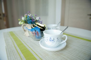 ucuz bir tatil odası misafirler için fincan, şeker ve çay poşetleri