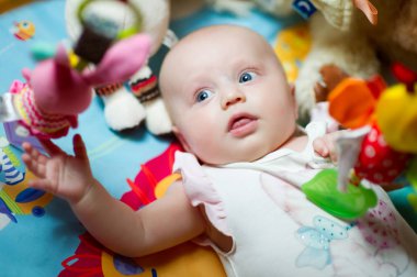 küçük bebek oyuncaklar yatıyor ve yukarı bakar
