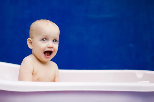Дівчинка сидить у білій ванні і посміхається — стокове фото