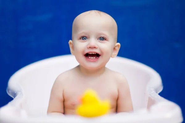 Дівчинка сидить у білій ванні і посміхається — стокове фото