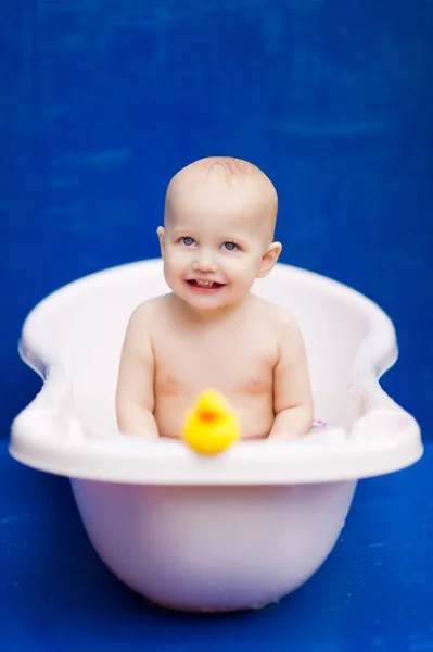 Дитина сидить у білій ванні і посміхається — стокове фото