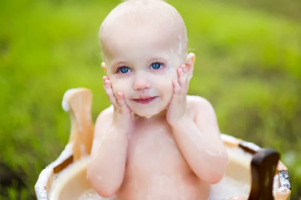 Grande retrato de uma menina de olhos azuis que segura as mãos em suas bochechas — Fotografia de Stock