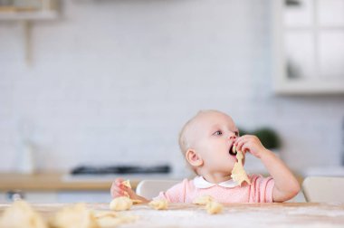 küçük kız ağzına bir parça hamur çeker