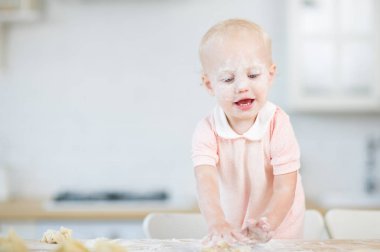 un bir yüzü ile bebek kız hamur ile oynar