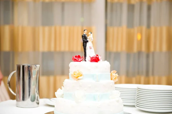 Hochzeitstorte mit Brautpaar-Figuren im Obergeschoss — Stockfoto