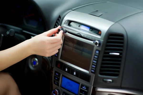 Hand Tunes in Radiosendern und die Anpassung der Lautstärke auf dem Auto-Audio-System. Parametereinstellungen über den Bordcomputer. Nahaufnahme — Stockfoto