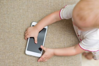 bebek kanepeden bir akıllı telefon alır