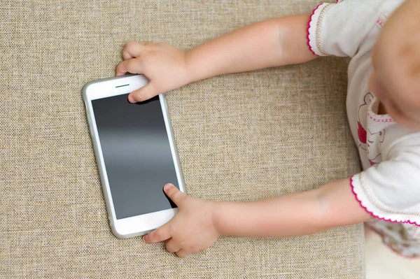 bebek kanepeden kilitli bir akıllı telefon alır