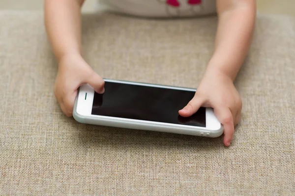 çocuk elinde bir akıllı telefon tutar