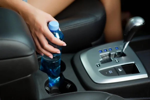 Kezében egy vizes palack egy pohártartó egy autóban — Stock Fotó