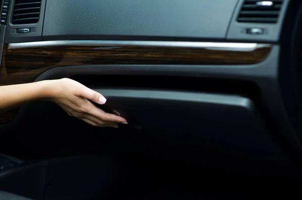 Vrouwelijke hand sluit het handschoenenkastje in de auto — Stockfoto