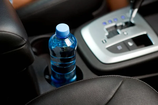 Eine Flasche Trinkwasser steht im Getränkehalter eines Autos — Stockfoto