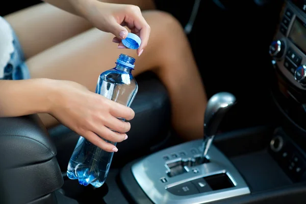 Een waterfles in een auto openen — Stockfoto