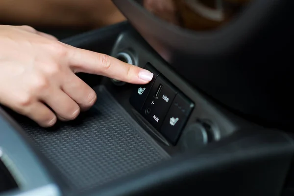 Hand schakelt op stoelverwarming in de auto — Stockfoto