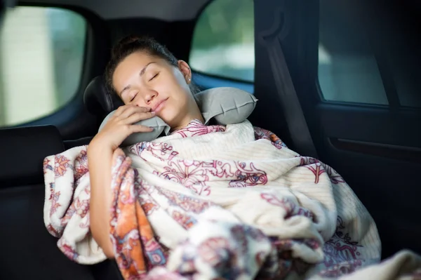 Νεαρή γυναίκα που κοιμάται στο πίσω κάθισμα ενός αυτοκινήτου — Φωτογραφία Αρχείου