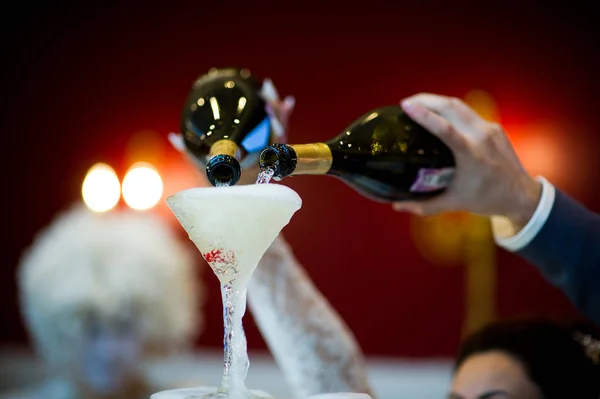 Les mains des mariés versent du champagne sur un toboggan des verres — Photo