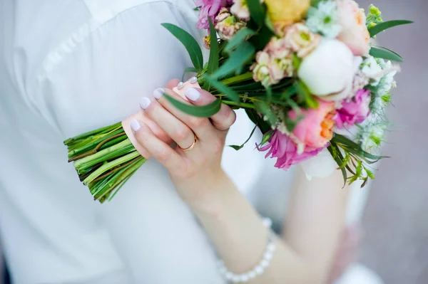 Bruid houdt een boeket in haar hand, het aanraken van de schouder van de bruidegom — Stockfoto