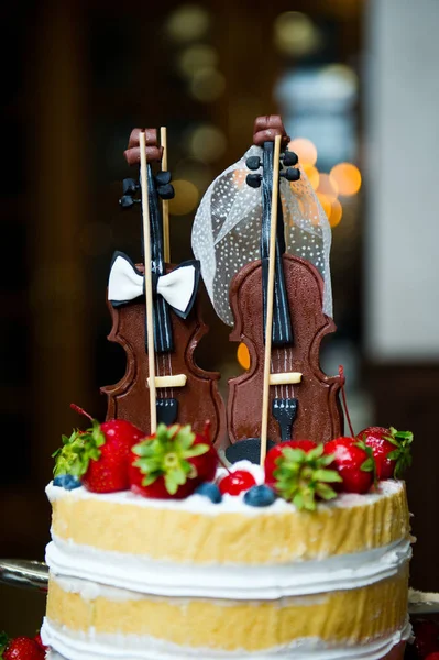 Essbare Figuren auf einem Kuchen in Form von zwei Geigen. vertikal — Stockfoto