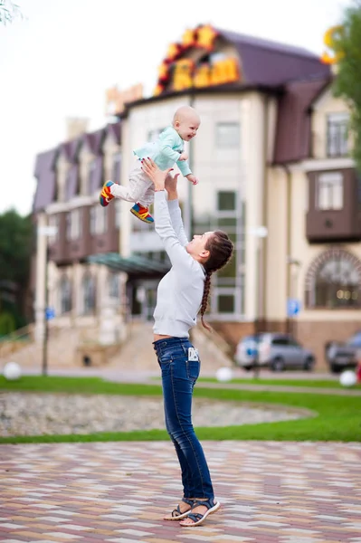 Mamma kastar den lilla dottern upp. vertikalt foto — Stockfoto