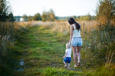 genç anne gün batımında bir kır yolda küçük kızı yalınayak yürüyor. Dadı çocukla birlikte yürüyor. Tonda