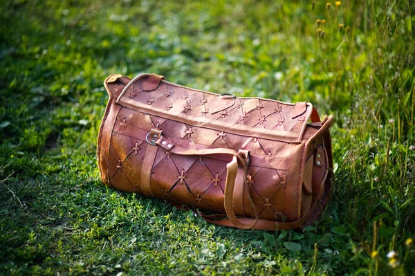 Bolso de cuero naranja en la hierba en una noche de verano. primer plano — Foto de Stock