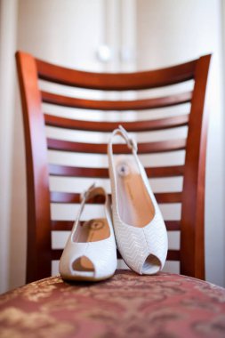 gelinin ayakkabıları bir sandalyede duruyor. Dikey çekim