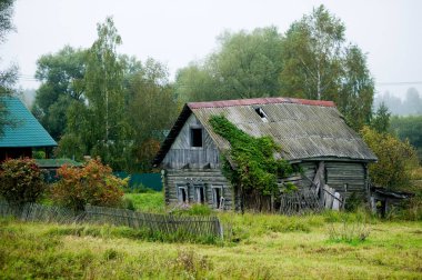 uzak bir köyde çürük eski ev. Çimenlerle kaplı arsa