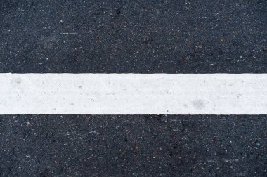 görüntünün merkezinde asfalt üzerinde beyaz yatay yol işaretleme hattı