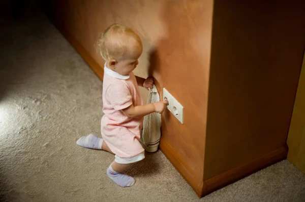 Baby spielt zu Hause mit Steckdose auf dem Boden — Stockfoto