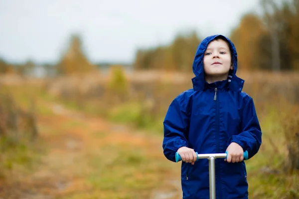 En pojke på en skoter tittar in i fjärran — Stockfoto