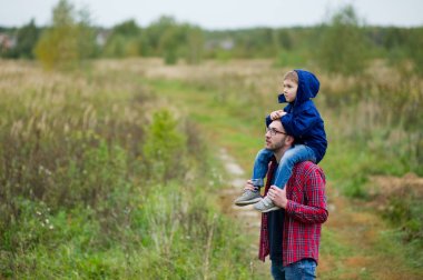 Oğul babasının omuzlarında oturur ve düz loks