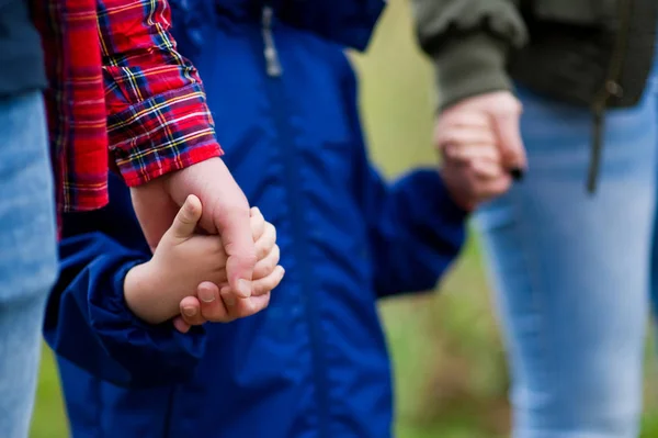 Föräldrarna håller sina händer. Utan ansikten. Fokusera på händerna — Stockfoto