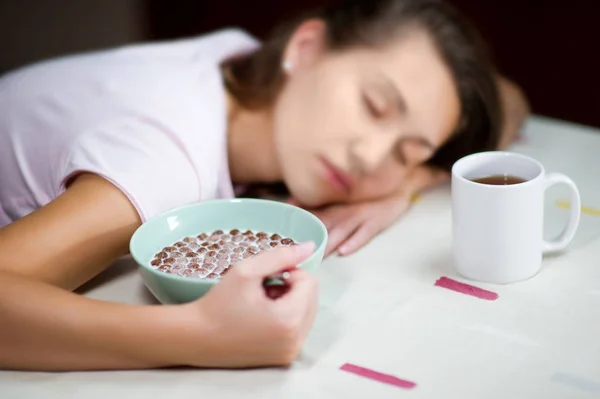 Молодая женщина уснула на столе за завтраком — стоковое фото