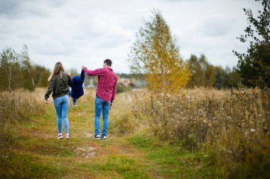 rahat giysiler içinde aile bir yolda yürümek