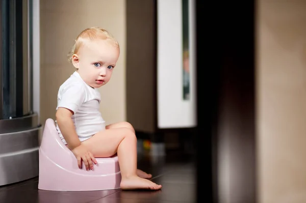 Bébé fille s'assoit sur un pot — Photo