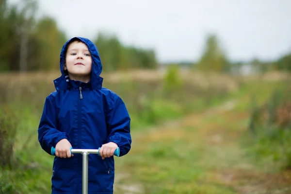 En pojke i en blå jacka i byn — Stockfoto