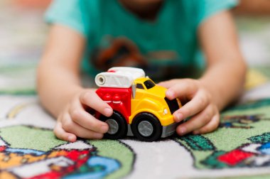 çocuk bir halı üzerinde bir oyuncak araba ile oynar