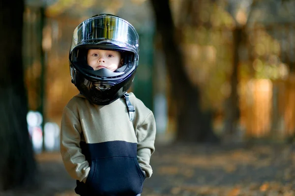 Divertente ragazzo con un grande casco moto sulla testa . — Foto Stock